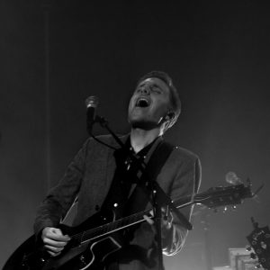 Lead guitarist performing a solo on an electric guitar under stage lights