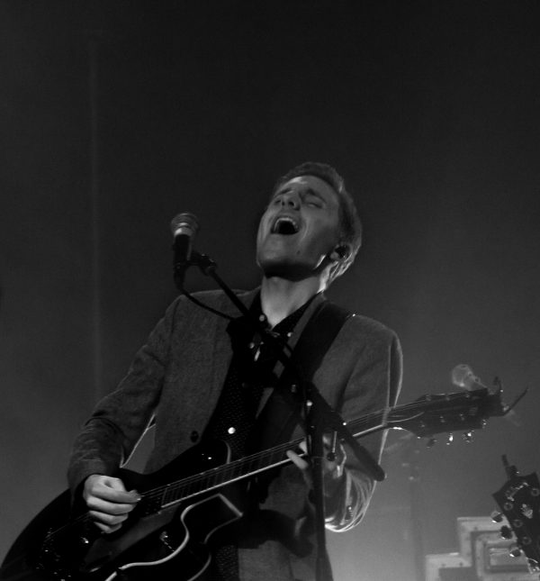 Lead guitarist performing a solo on an electric guitar under stage lights